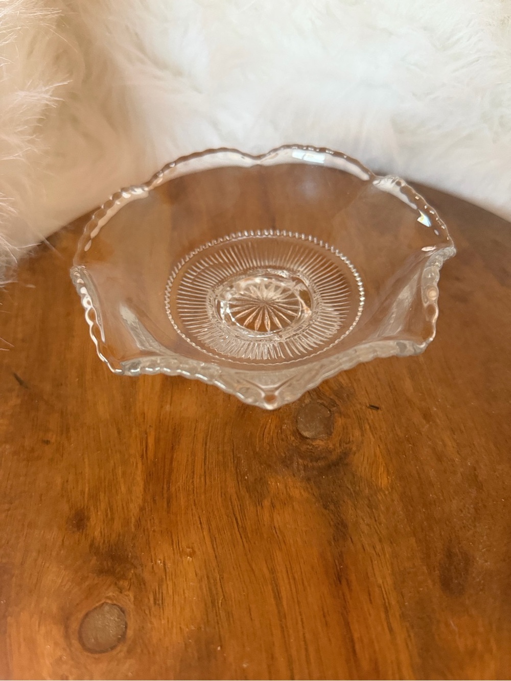 Clear pressed glass candy dish with starburst pattern and ruffled edge.